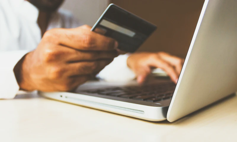 Persona comprando online con laptop y tarjeta de crédito